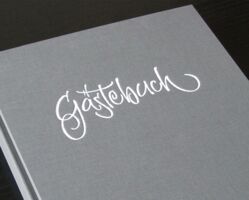 The cover of a guest book embossed with an individually made title saying “guest book”.