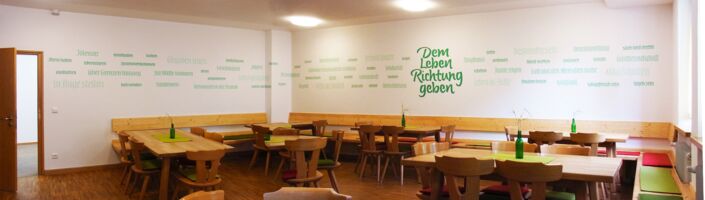 The staff of a Catholic convention centre in Bavaria developed a mission statement and they wanted 60 words/terms of it to be displayed on two walls in one of the recreation/common rooms with the title in the center.